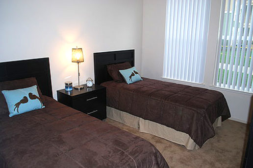 Two twin beds with nightstand and lamp, two windows 