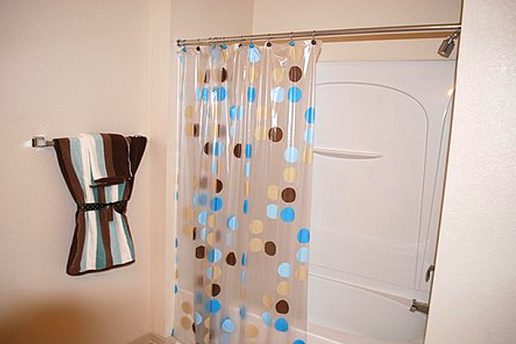 Shower/tub combo with polka dot shower curtain with towel on rack